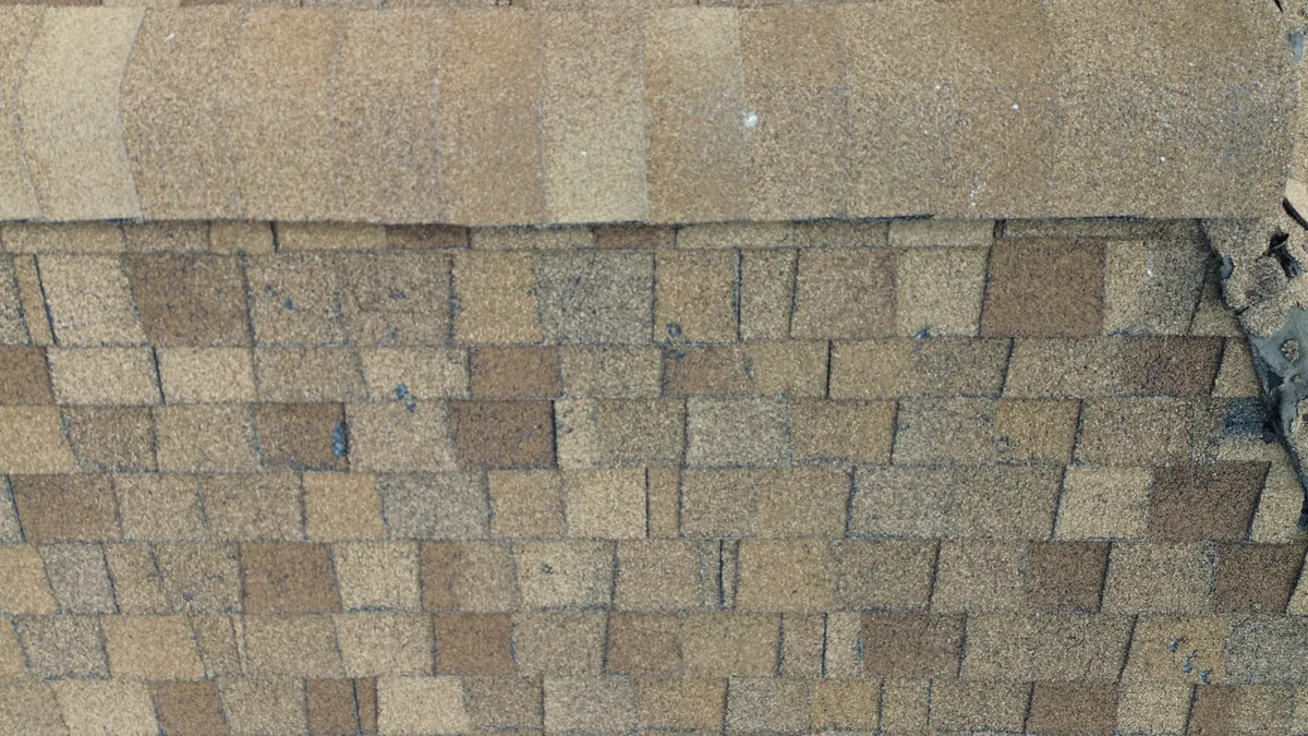 Roofer checking the edge of a Utah home for multiple shingle layers