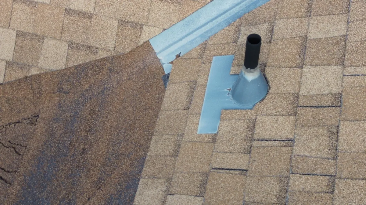 Professional roof snow removal being performed safely with specialized tools