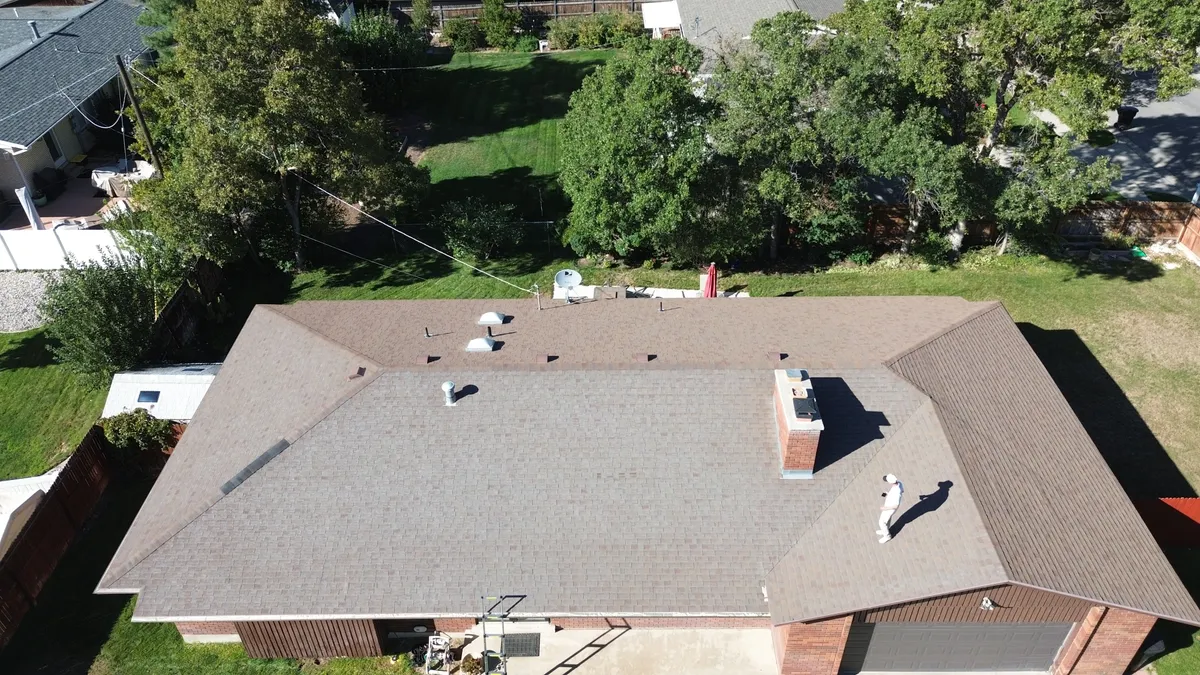 Abandoned swamp cooler unit being craned off a Utah roof during replacement