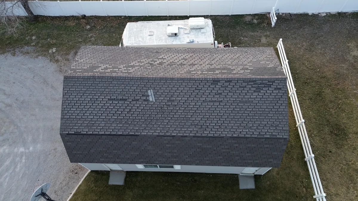 Sky Ridge representative explaining gutter integration with new roofing shingles