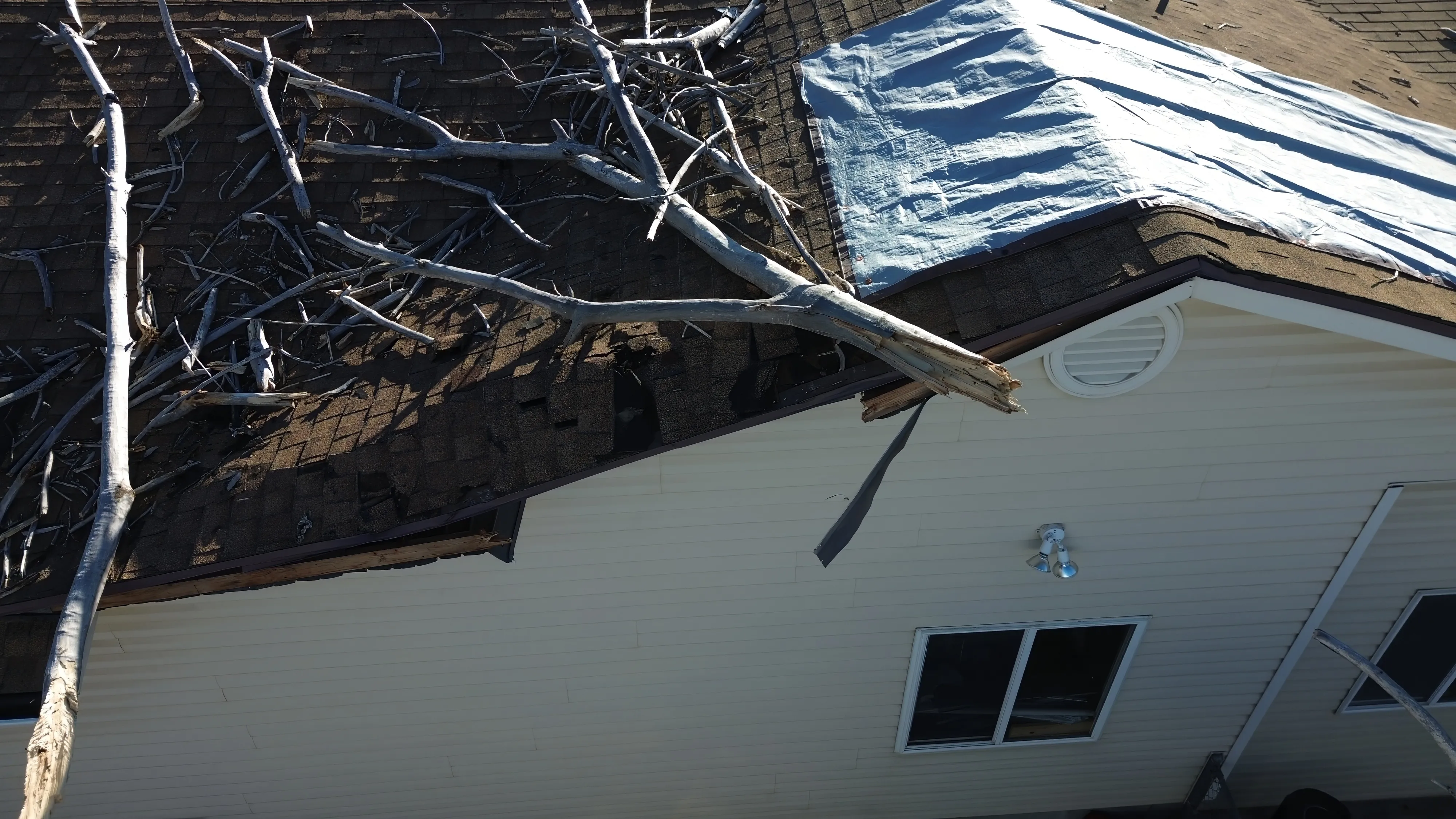 A professional roofing technician performing a forensic leak audit on a Utah home with mountains in the background